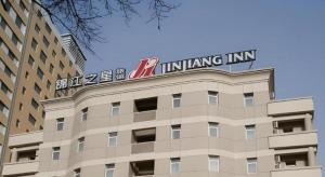 um edifício com um sinal em cima em Jinjiang Inn Changchun Xi An Avenue Branch em Changchun