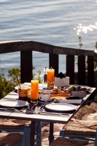 a table with food and drinks on a table overlooking the ocean at Akrotiri Olympus Luxury Suites - Adults Only in Plaka Litochorou