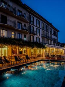 un hotel con piscina di fronte a un edificio di Hotel Bellavista a Menaggio