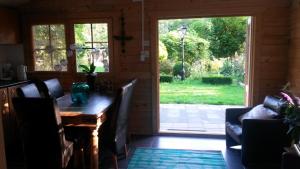 comedor con mesa y puerta corredera de cristal en GUESTHOUSE in een mooie tuin in het centrum van Zuidlaren!, en Zuidlaren