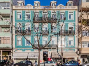 un edificio blu con un albero di fronte di Vila Garden Guesthouse a Lisbona