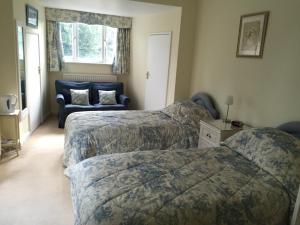 A bed or beds in a room at Kingswood Cottage