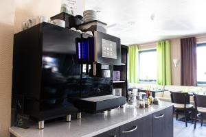 a kitchen with a large black appliance on a counter at Hotel Aulmann in Trier