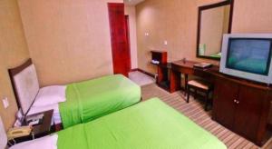 a hotel room with a green bed and a television at Super 8 Hotel Xian Nanshaomen in Xi'an