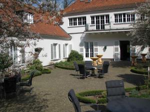 un patio con sedie e tavolo di fronte a una casa di Gästehaus Villa Wolff a Bomlitz