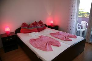 een slaapkamer met een bed met roze handdoeken bij Vila in Lavanda in Fažana