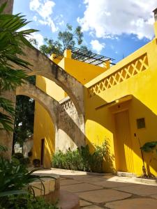 un edificio giallo con un arco in un cortile di Bungalows Demetria a Guadalajara