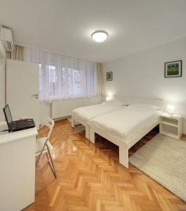 - une chambre avec un lit et un bureau avec un ordinateur portable dans l'établissement Apartment Osijek-Tvrda, à Osijek