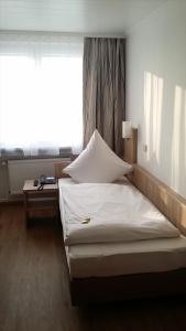 a bed in a room with a large window at Hotel Rheinkrone in Koblenz