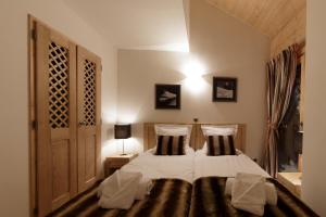 een slaapkamer met een bed met 2 kussens bij CGH Résidence Boutique Les Chalets De Laÿssia in Samoëns