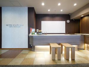 a kitchen with two stools and a counter with a whiteboard at Hotel Route-Inn Akita Tsuchizaki in Akita