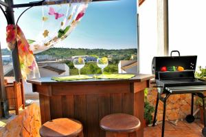 un bar su un balcone con computer portatile e bicchieri da vino di Casa Encosta do Sol a Lagos