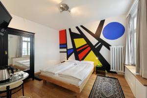 - une chambre avec un lit et une peinture murale dans l'établissement Hotel National Bern, à Berne