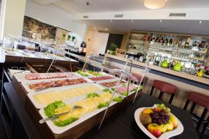 uma linha de buffet com muitos tipos diferentes de alimentos em HOTEL PARQÉO im A66 em Gelnhausen