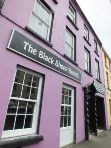 un bâtiment rose avec un panneau qui lit le bâché noir dans l'établissement The Black Sheep Hostel, à Killarney