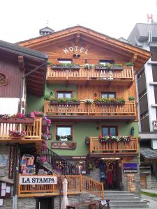 een gebouw met houten balkons en bloemen erop bij Hotel Meublé Gorret in Breuil-Cervinia