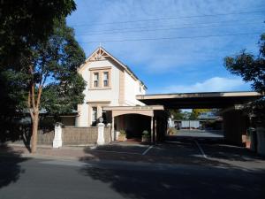 ein weißes Haus mit einer Garage davor in der Unterkunft Jasper Motor Inn in Adelaide