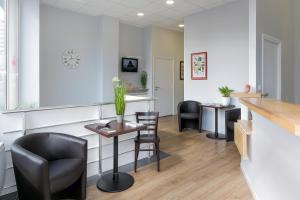 une salle d'attente dans une clinique avec des chaises et un comptoir dans l'établissement Hotel Foch Nancy Gare, à Nancy