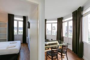 une chambre d'hôtel avec un lit, une table et des chaises dans l'établissement Hotel Foch Nancy Gare, à Nancy