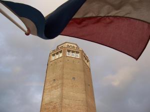 uma torre alta com uma bandeira em frente em Pension & Spa de Watertoren em Zandvoort