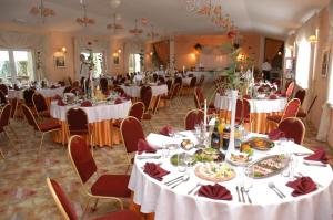 um salão de banquetes com mesas e cadeiras brancas em Dedek Park - historyczny dworek w pięknym Parku Skaryszewskim obok Stadionu Narodowego em Varósvia