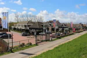 een straat met huizen en auto's in een stad bij Hotel Restaurant 't Klokje in Renesse