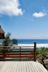 una terrazza in legno con vista sull'oceano di The Island Houses Bingin a Uluwatu