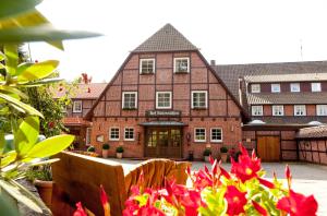 Un bâtiment avec un bouquet de fleurs devant lui dans l'établissement Hotel Hof Sudermühlen, à Egestorf