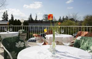 un tavolo con bicchieri da vino e un fiore sul patio di Hotel Atrium a Vyškov