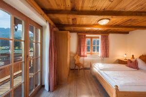 sypialnia z łóżkiem i dużym oknem w obiekcie Landhotel Vordergrub w mieście Kitzbühel