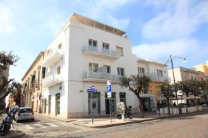 ein weißes Gebäude an der Ecke einer Straße in der Unterkunft Hotel Città Bella in Gallipoli