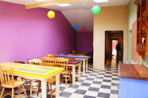 un restaurant avec des tables, des chaises et des murs violets dans l'établissement The Black Sheep Hostel, à Killarney