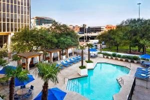 een uitzicht over een zwembad met stoelen en parasols bij The Whitehall Houston in Houston