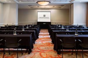 een conferentieruimte met tafels en stoelen en een scherm bij The Whitehall Houston in Houston