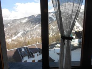 a window with a view of a snow covered mountain at Monolocale Milky Way - Sestriere in Sestriere