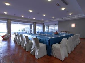 een grote kamer met een lange tafel en witte stoelen bij Parador de Málaga Golf in Málaga