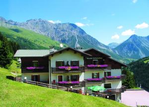 ein Haus auf einem Hügel mit Bergen im Hintergrund in der Unterkunft Meublè Rosalpina in Valdidentro