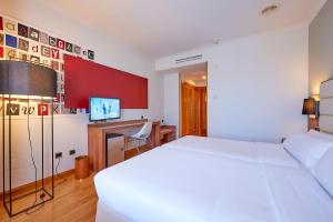 - une chambre avec un lit blanc et un bureau dans l'établissement Hotel Vigo Los Galeones Affiliated by Meliá, à Vigo