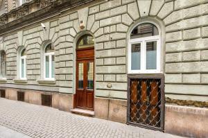 um edifício de tijolos com uma porta de madeira e janelas em Budapest Citi Guesthouse - self check in em Budapeste