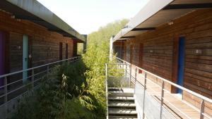 un balcón de un edificio con escaleras y plantas en Auberge des VoyaJoueurs, en Monteneuf