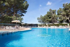 una grande piscina con sedie e ombrelloni di Grupotel Orient a Playa de Palma