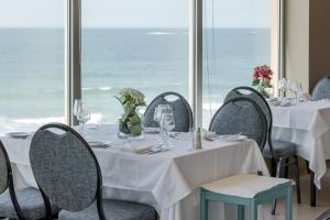 uma sala de jantar com mesas e cadeiras com vista para o oceano em Axis Ofir Beach Resort Hotel em Esposende