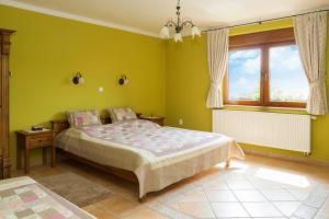 a green bedroom with a bed and a window at Rekreačný dom SISI in Podhájska