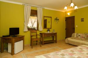 a bedroom with a bed and a desk with a television at Rekreačný dom SISI in Podhájska