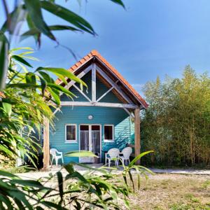 una casa blu con sedie e portico di Naturotel a Fort-Mahon-Plage