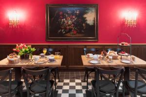 une salle à manger avec deux tables et un tableau mural dans l'établissement Hotel im Hof, à Munich