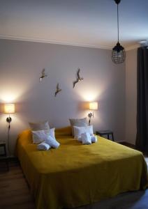 - une chambre dotée d'un lit jaune avec des oiseaux sur le mur dans l'établissement O Forte Guest House, à Peniche