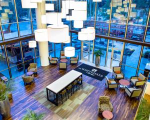 een uitzicht over de lobby met stoelen, tafels en kroonluchters bij The Whitehall Houston in Houston