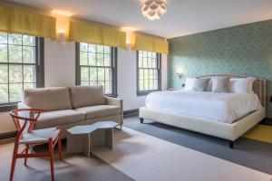 een slaapkamer met een bed, een bank en een stoel bij The Poppy Georgetown Guesthouse and Gardens in Washington