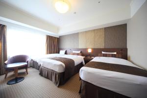 سرير أو أسرّة في غرفة في Hotel Metropolitan Nagano